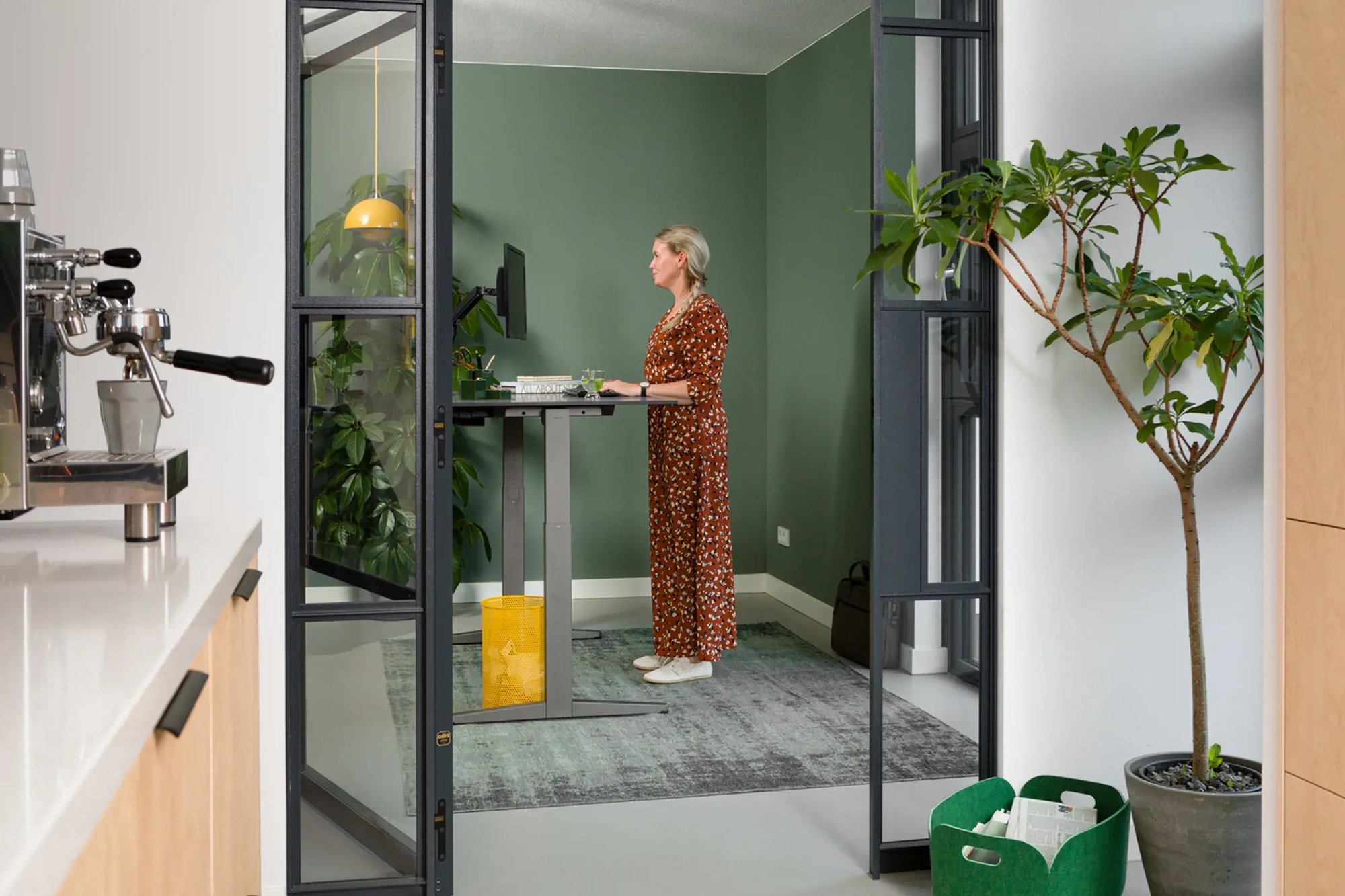 landscapexl-royal-ahrend-balance-workstation-in-grey-with-charcoal-tabletop-in-standing-position-with-female-model-interior-view